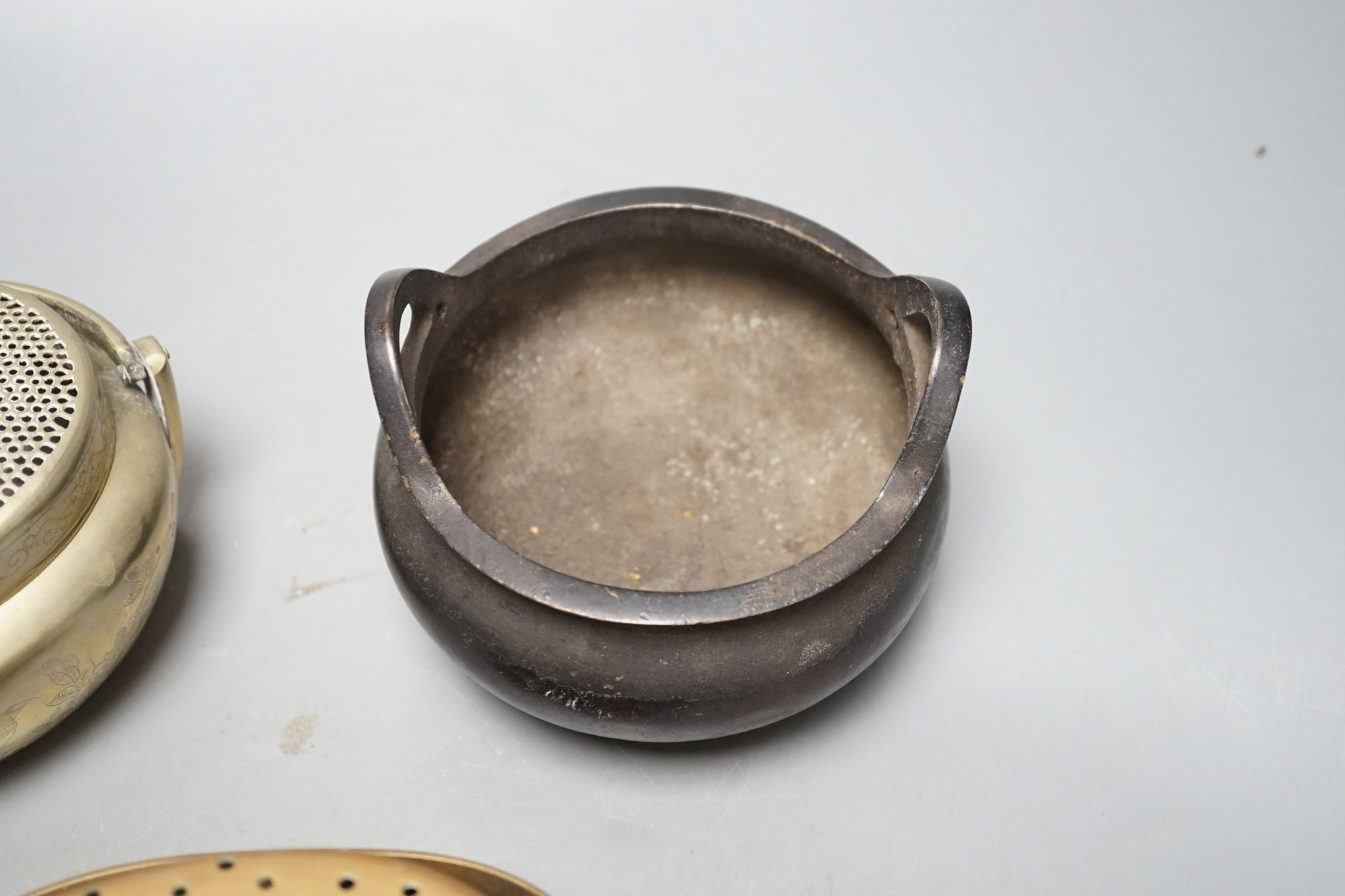 A Chinese bronze tripod censer, 13.5cm and two brass or bronze hand warmers